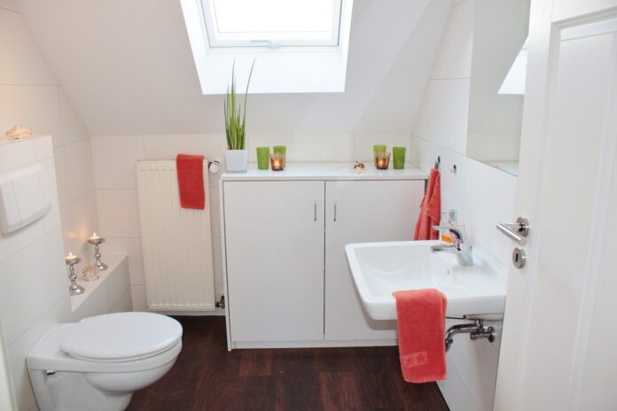 A clean and modern bathroom with a toilet, sink, and natural light, symbolizing the importance of digestive health and open communication with your doctor.