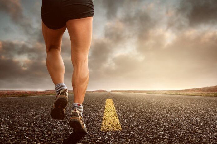 A runner's legs in motion, pounding the pavement on a sunny day, symbolizing the vitality and energy that comes with a strong immune system.