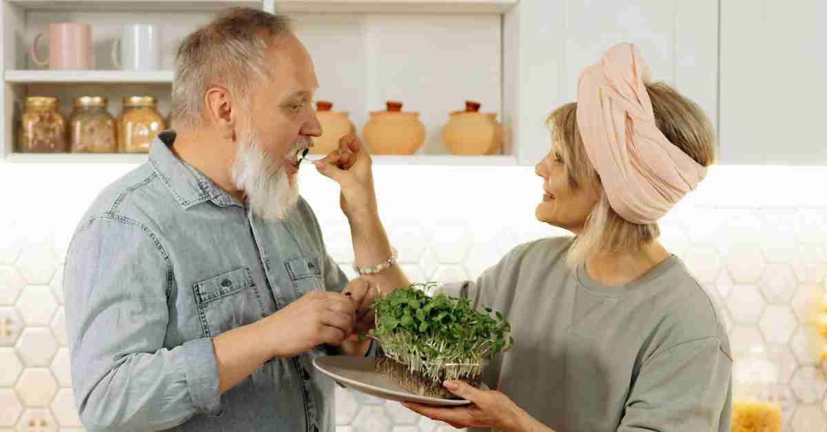 Two healthy mature adults enjoying a toxic free microgreens straight from the garden