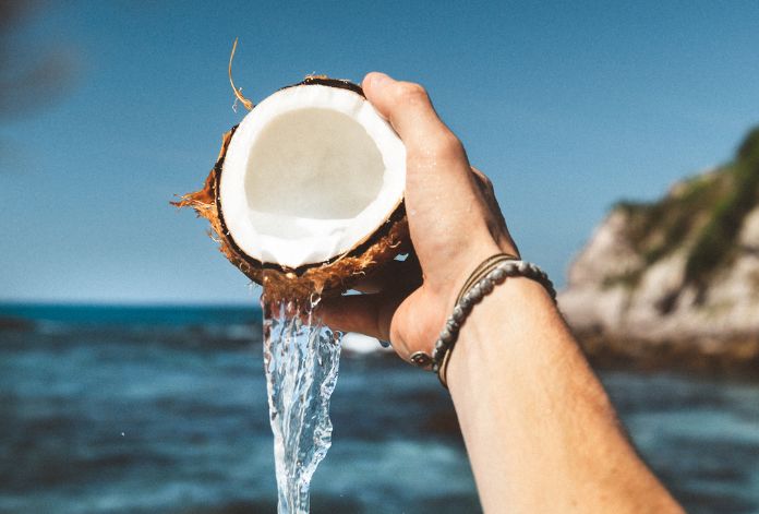 Coconut water with tropical background, highlighting sexual health benefits