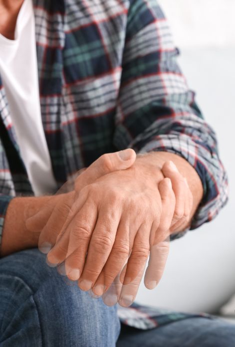 A close-up image of a person's hand exhibiting tremors, a characteristic symptom of Parkinson's disease.