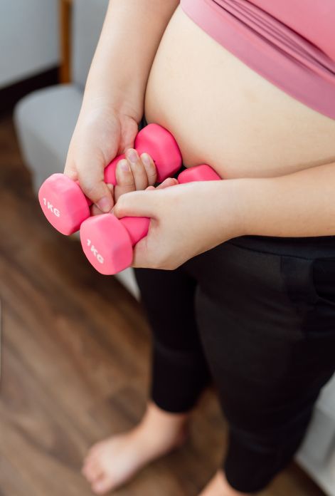Obese woman in workout clothes holding dumbbells, determined to lose weight and get healthy.